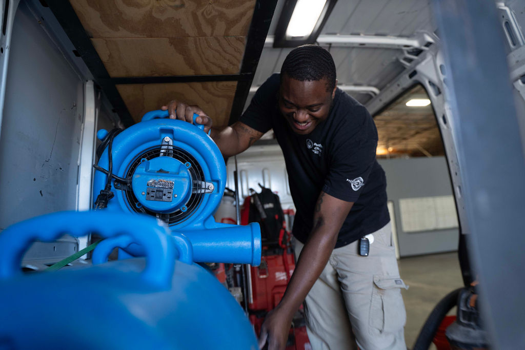 Air mover drying a water-damaged room after extraction