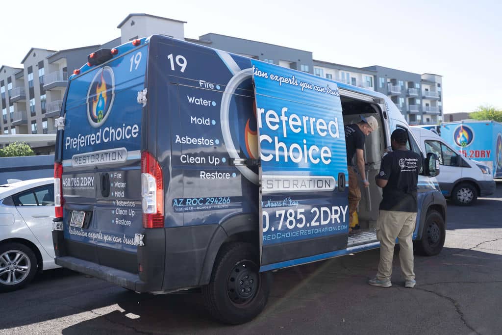 Preferred Choice technicians unloading equipment from a branded van at a Phoenix apartment complex